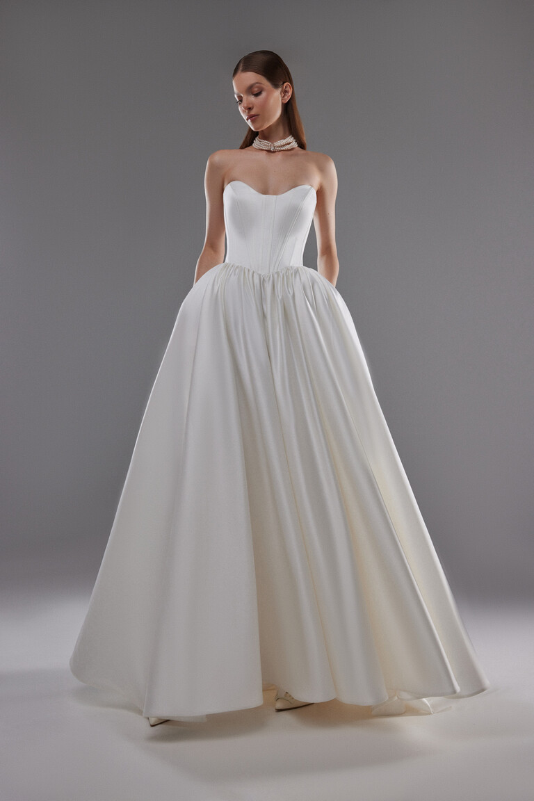 Voluminous Satin Ball Gown Skirt Detail Full length view of Olvia ivory wedding dress featuring pleated satin ball gown skirt and boned bodice