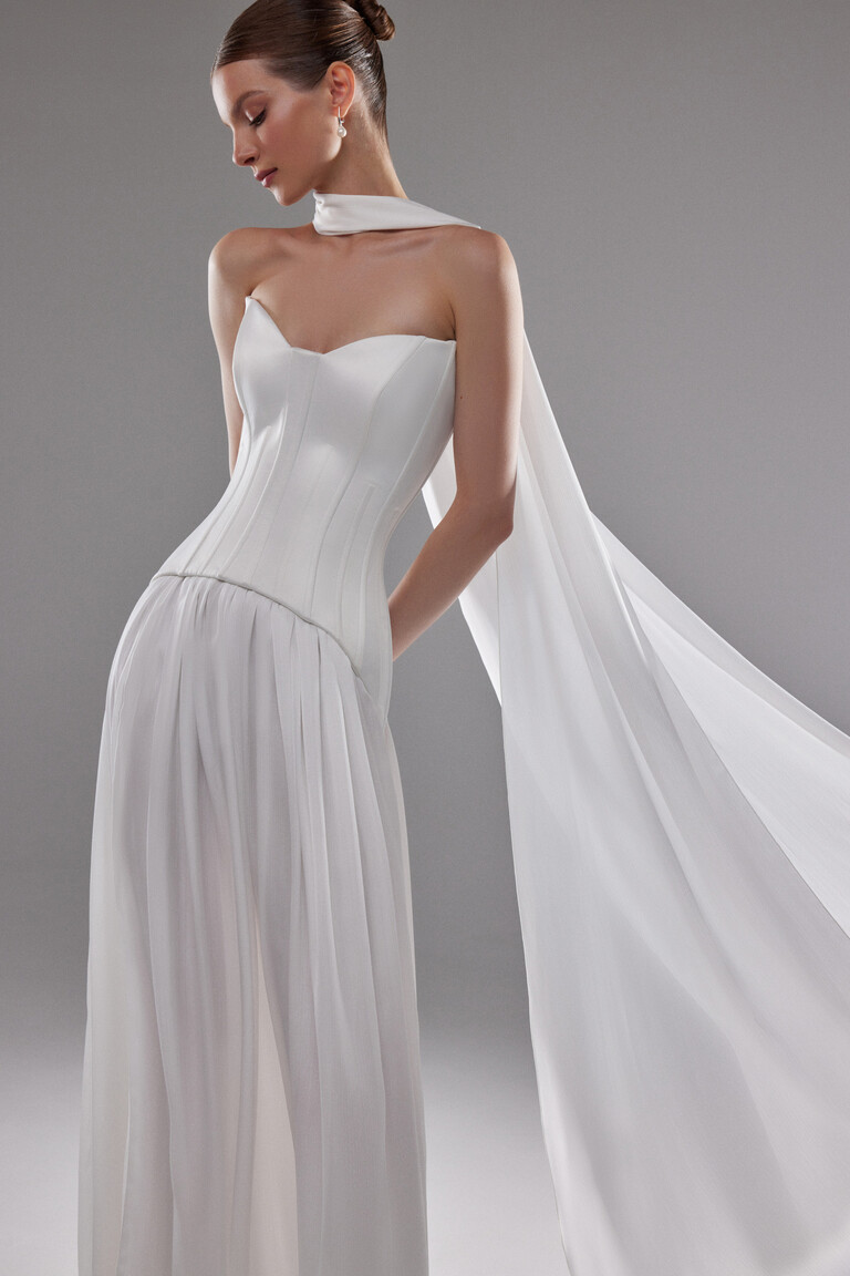 Detail shot of off-white satin lace-up corset top and draped silk skirt on Artemide gown