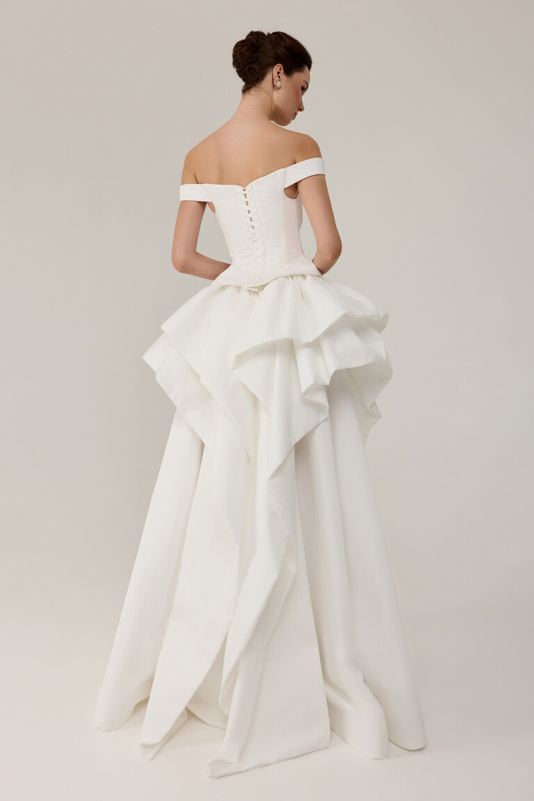 Back view of Alana bridal gown featuring corset lacing and structured bustle with cascading ruffles