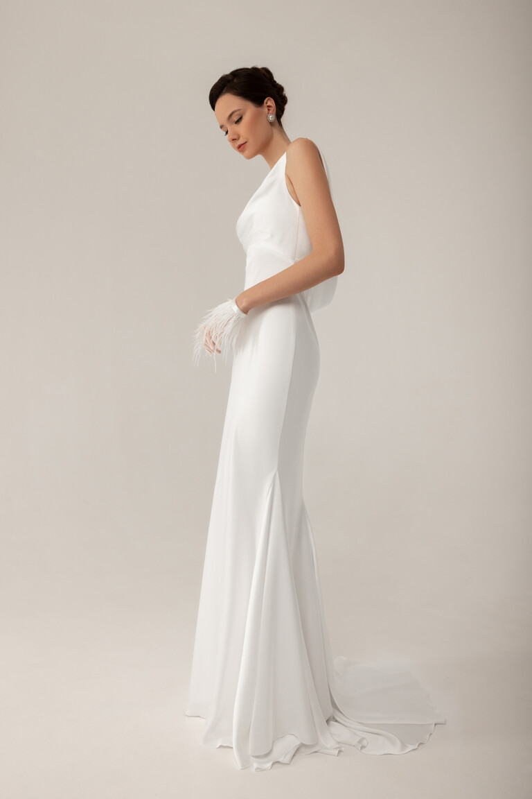 Side profile of Lea sleeveless satin bridal gown displaying fitted mermaid silhouette