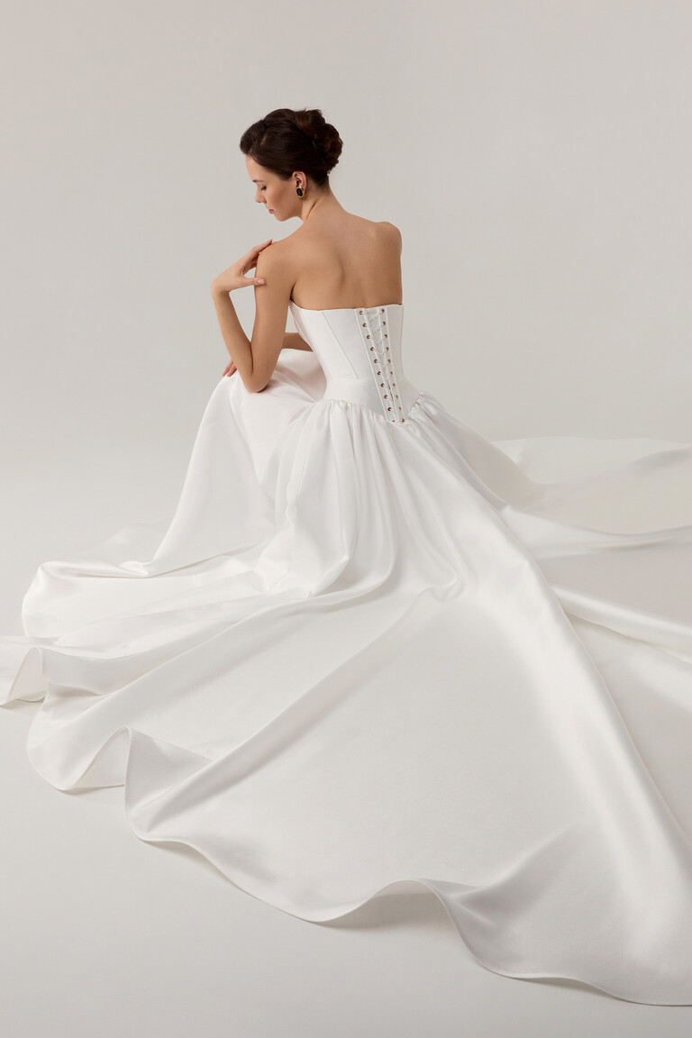 Back view of Faith wedding dress with lace-up corset closure and voluminous off-white Mikado skirt