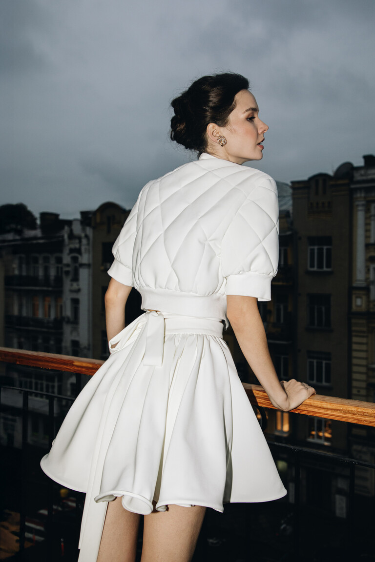 Back view of Teddy off-white bridal jacket showing quilted pattern and elastic waistband