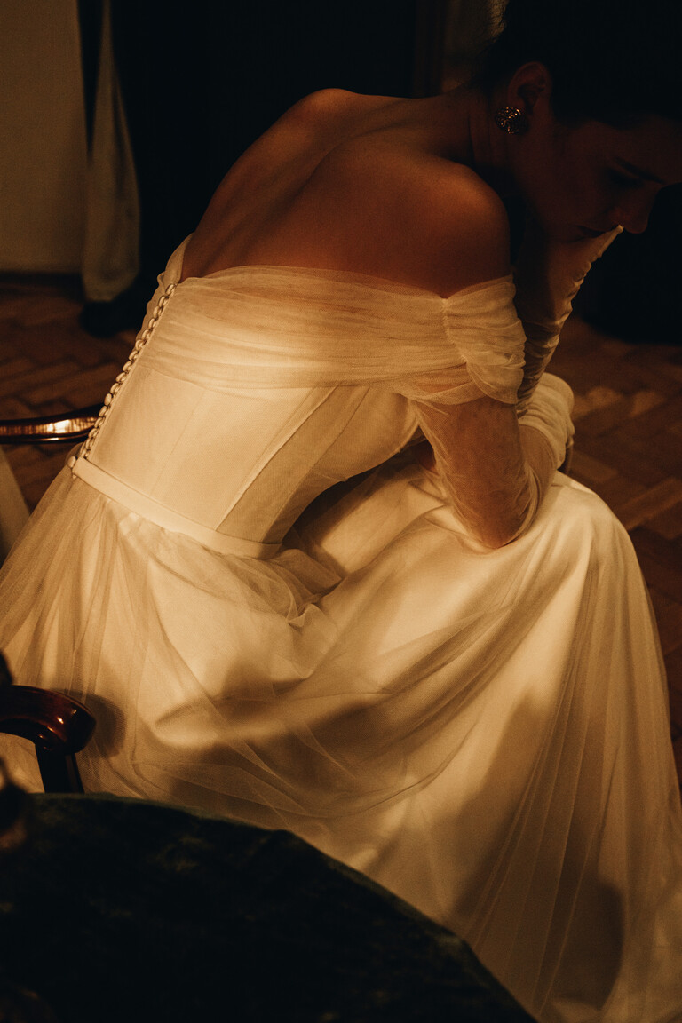 Rose Corset Dress Side View & Structure Side view of seated Unona Rose corset dress highlighting structural seams