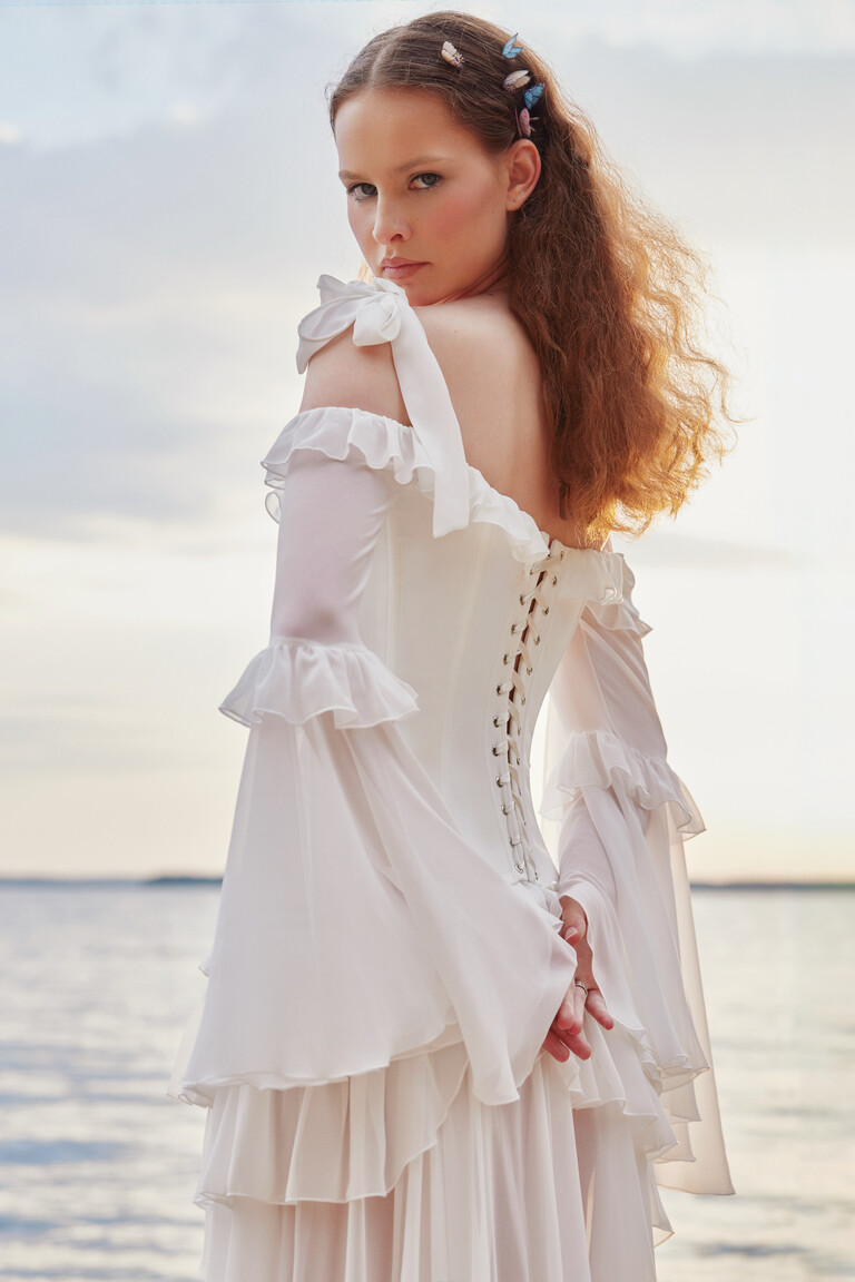 Close-up of Riot gown lace-up back fastening and sheer sleeves with bow ties