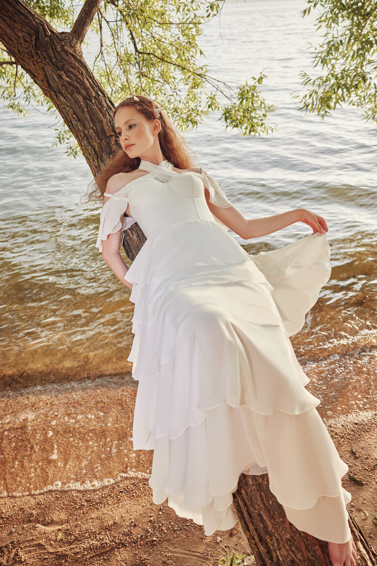 Full length Sia bridal gown outdoors showing halter neckline and flowing ruffled layers