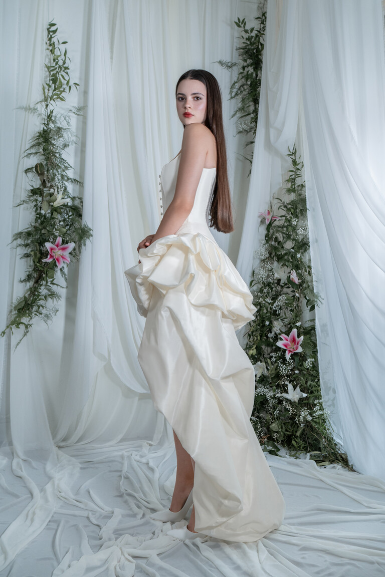 Side view of Amira Champagne dress showing high-low silhouette and flowing taffeta train