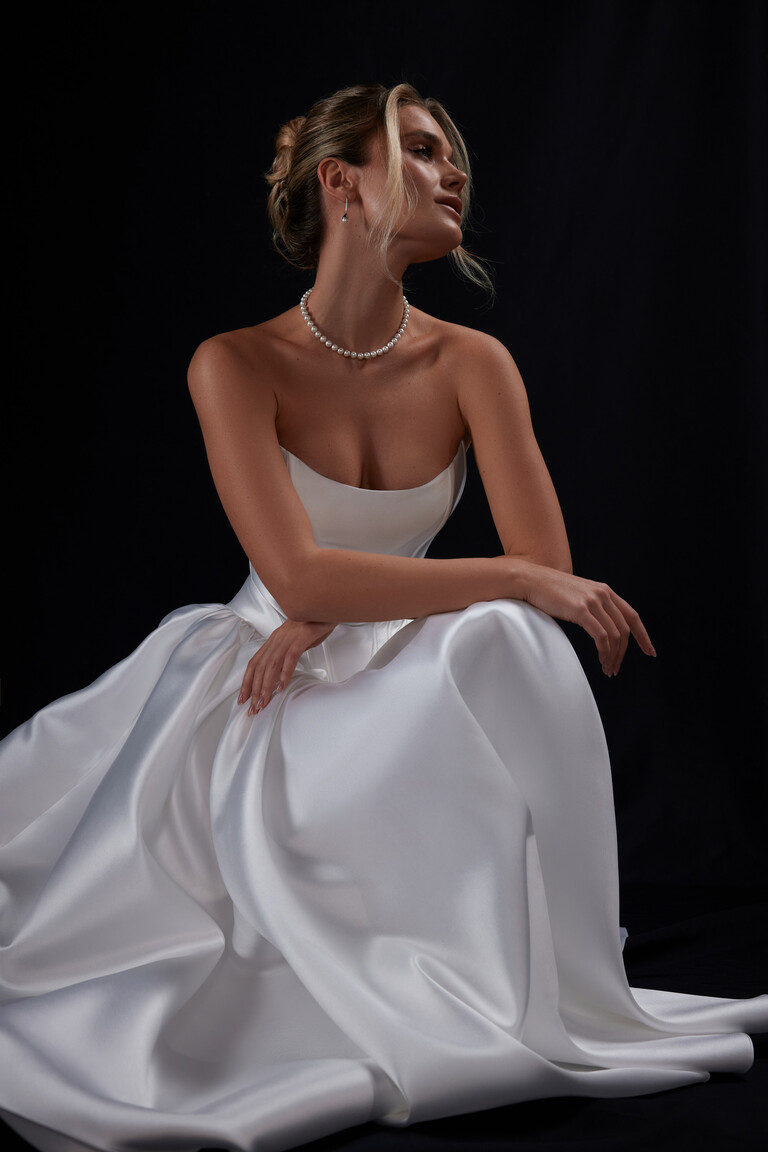 Faith strapless wedding dress seated view showing neckline and skirt folds
