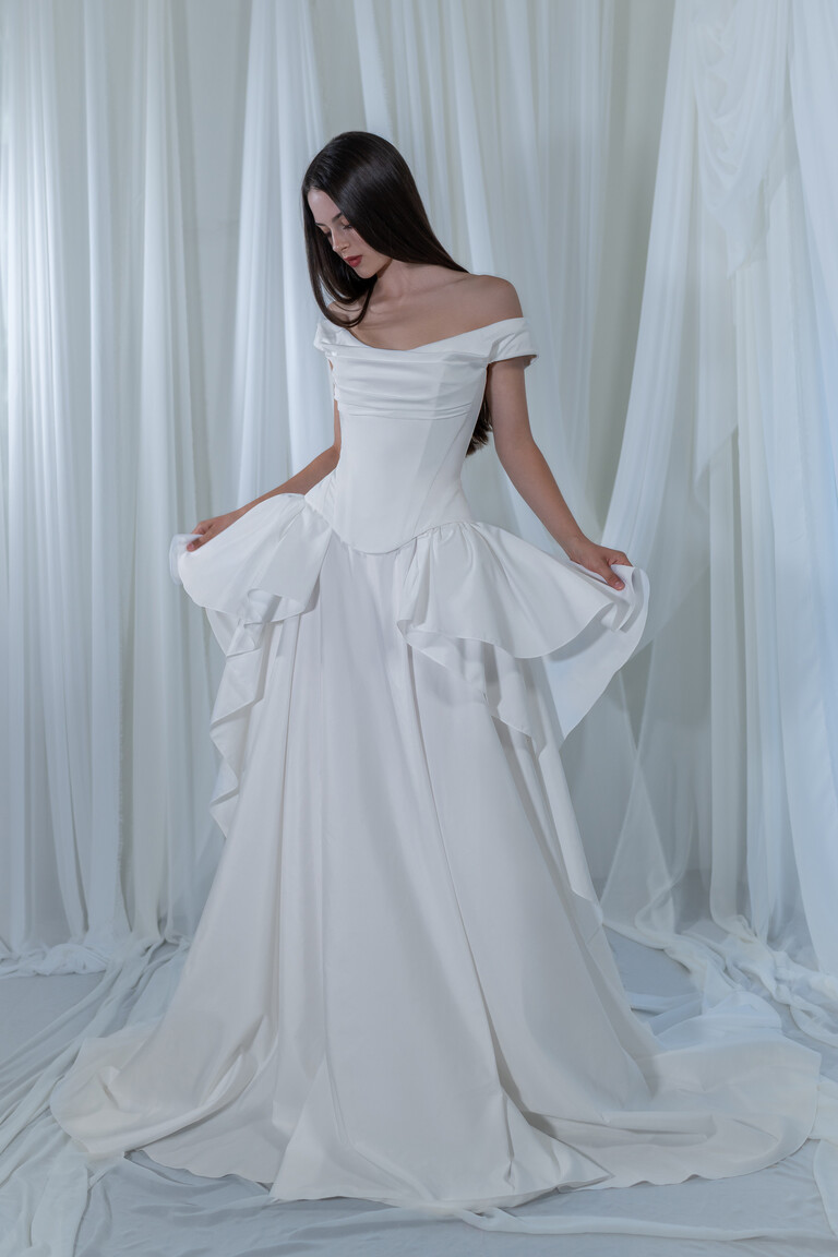 Bride wearing Paradise ruffled taffeta gown holding the voluminous skirt with basque waist