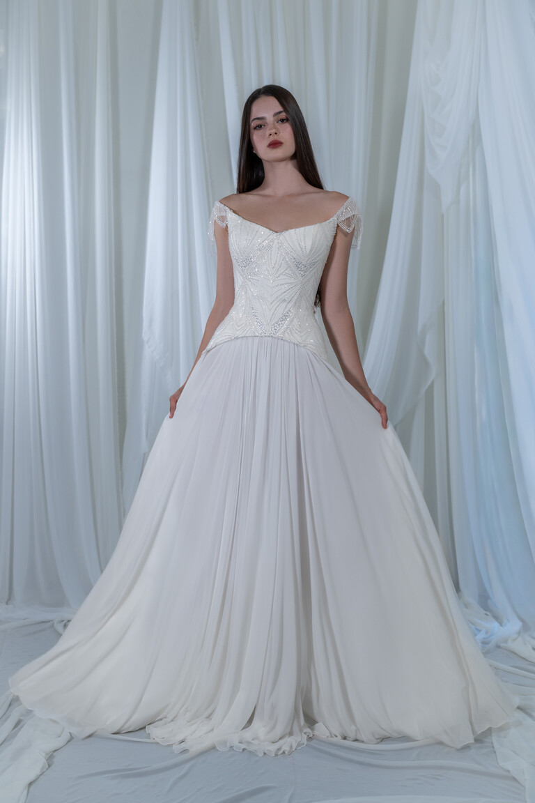 Divine wedding dress featuring pointed basque waistline and floor-length flowing chiffon skirt