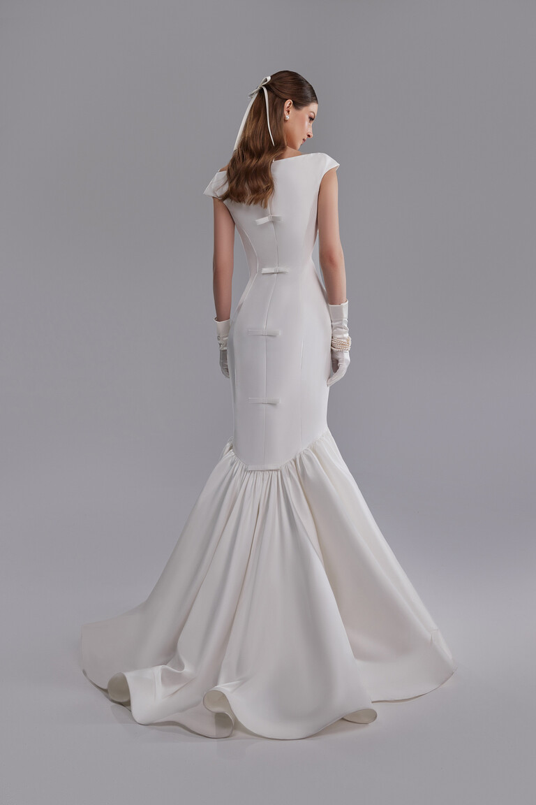 Back view Rachel mermaid wedding dress featuring cascade of bows and gathered train