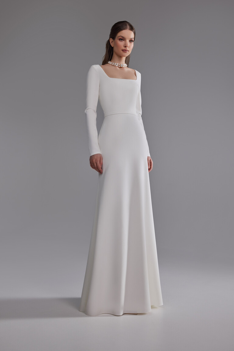 Elegant Long Sleeve Crepe Bridal Gown Angled view of Brittany long sleeve sheath wedding dress in off-white stretch crepe by Unona