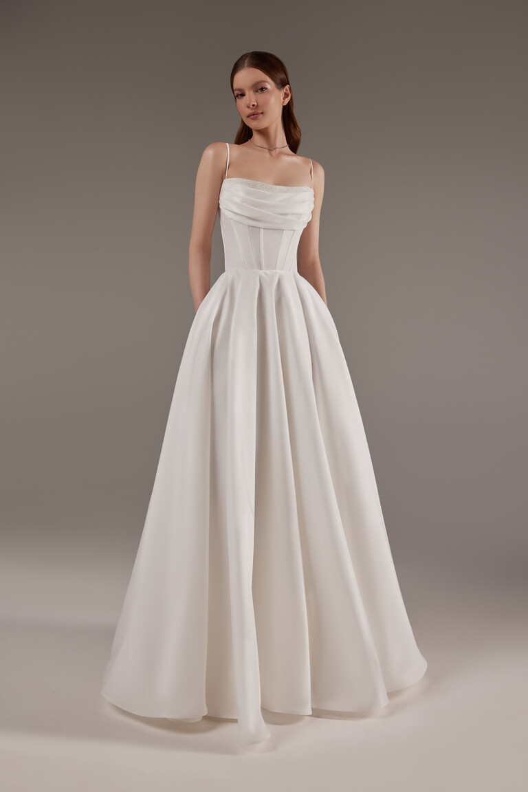 Minimalist Satin Gown with Delicate Beaded Neckline Unona Rihanna ivory satin wedding dress with beaded neckline trim and pleated A-line skirt