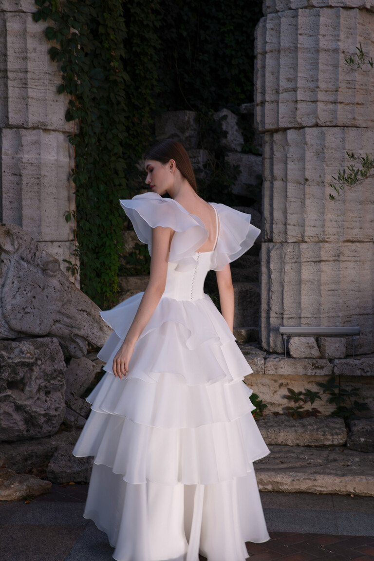 Back view of Cvit off-white bridal gown with row of covered buttons and voluminous sheer sleeves