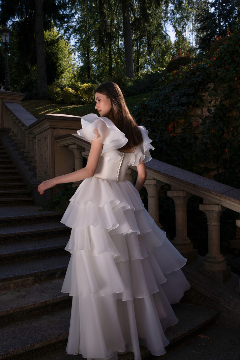 Cvit ball gown silhouette back view showing voluminous tiered organza skirt and stone staircase