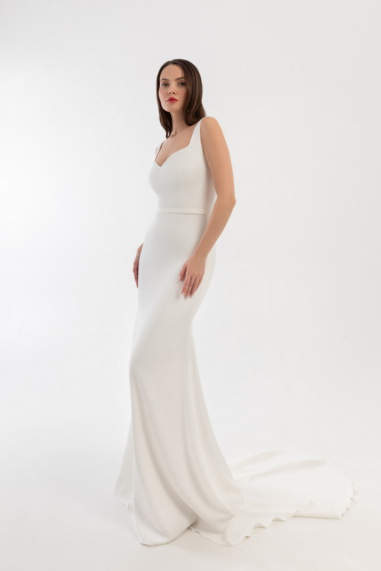 Justina stretch crepe bridal gown side view showing fitted bodice and long train in off-white