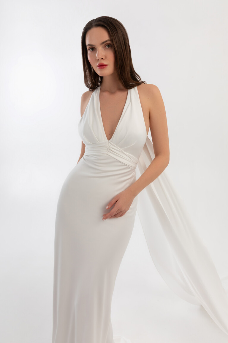 Front view of Athena fitted bridal gown with deep V-neck and long flowing shawl attachment