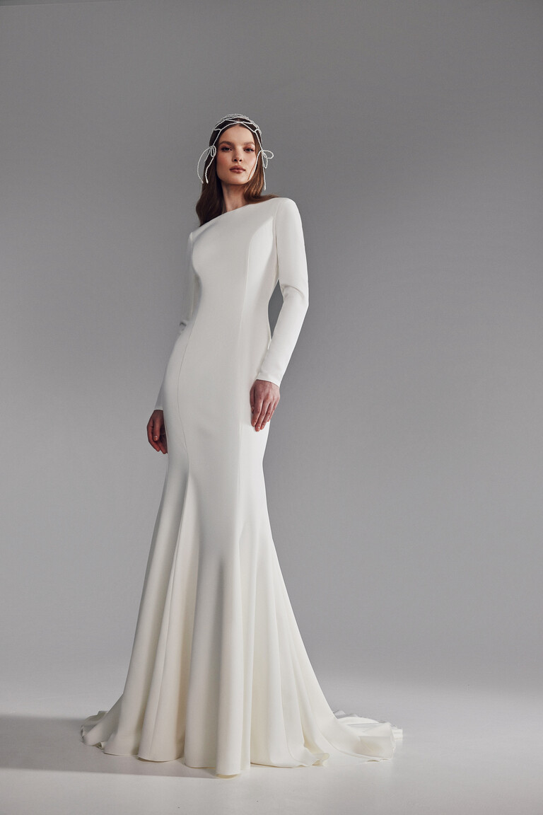 Unona Odetta long sleeve bridal gown styled with beaded headpiece and fitted silhouette