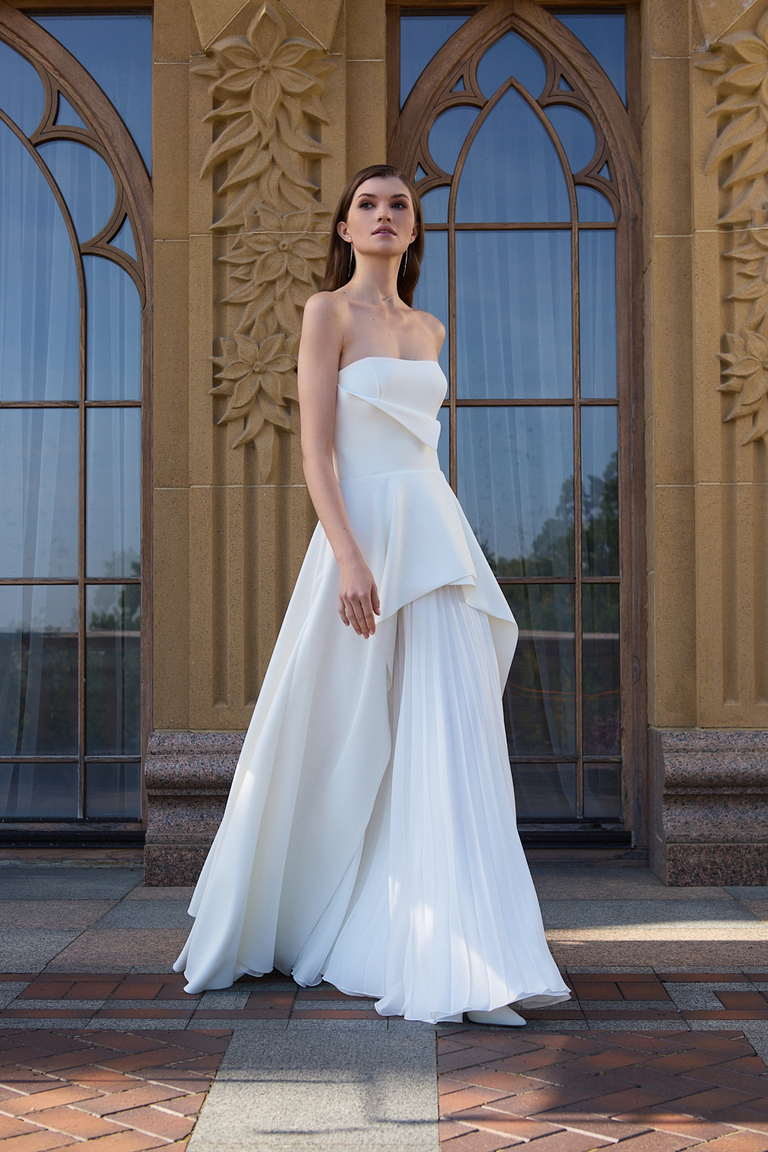 Minimalist Strapless Dress with Layered Skirt Design Leyana off-white bridal gown with minimalist asymmetric neckline and flowy pleated chiffon skirt