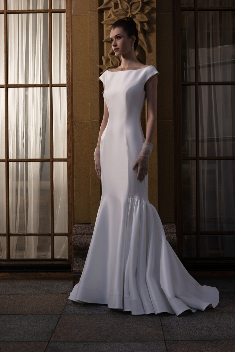 Rachel off-white mikado mermaid gown front view in architectural setting with gloves
