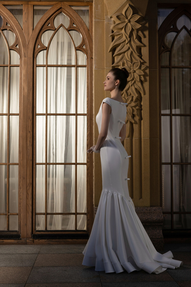 Side profile Rachel mermaid wedding dress showing fitted hips and back bow details
