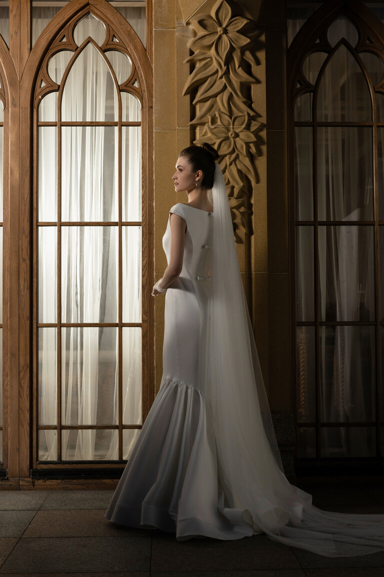 Profile view Rachel off-white mermaid gown with back bows and long sheer veil