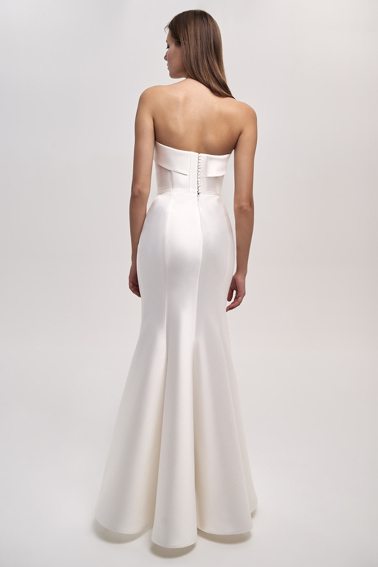 Back view of Unona Gala mermaid bridal gown featuring row of covered buttons and flared skirt