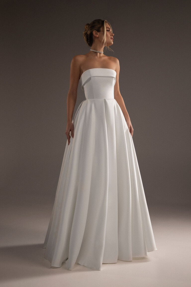 Sophie strapless ivory wedding dress featuring a straight neckline with cuff and pleated skirt