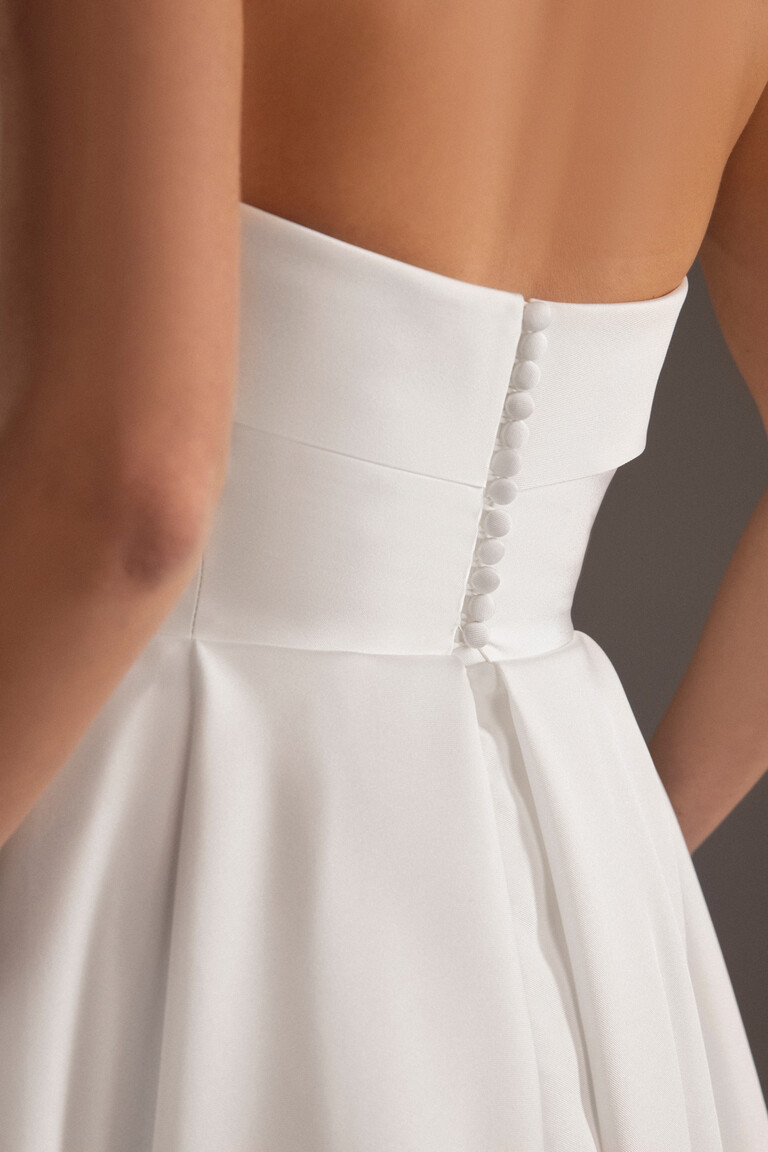 Close up detail of Sophie dress back featuring fabric covered buttons on the strapless bodice
