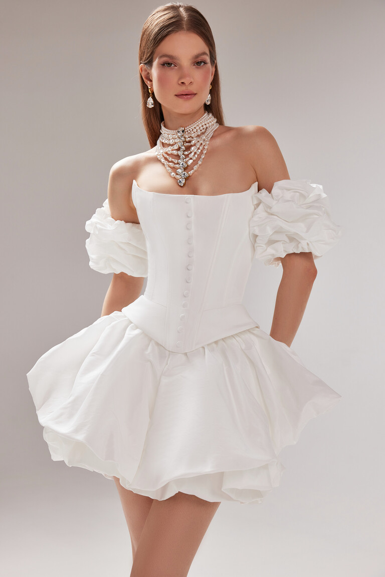 Three-quarter view of the Amira Mini ivory party dress with voluminous detachable sleeves, corset top, and bubble skirt.