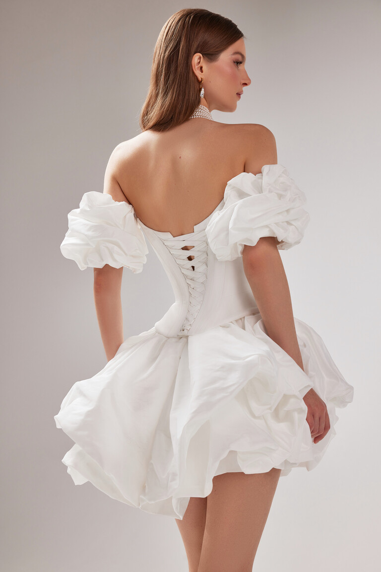 Back view of the Amira Mini dress by Unona featuring the lace-up corset and detachable puff sleeves with the bubble skirt.