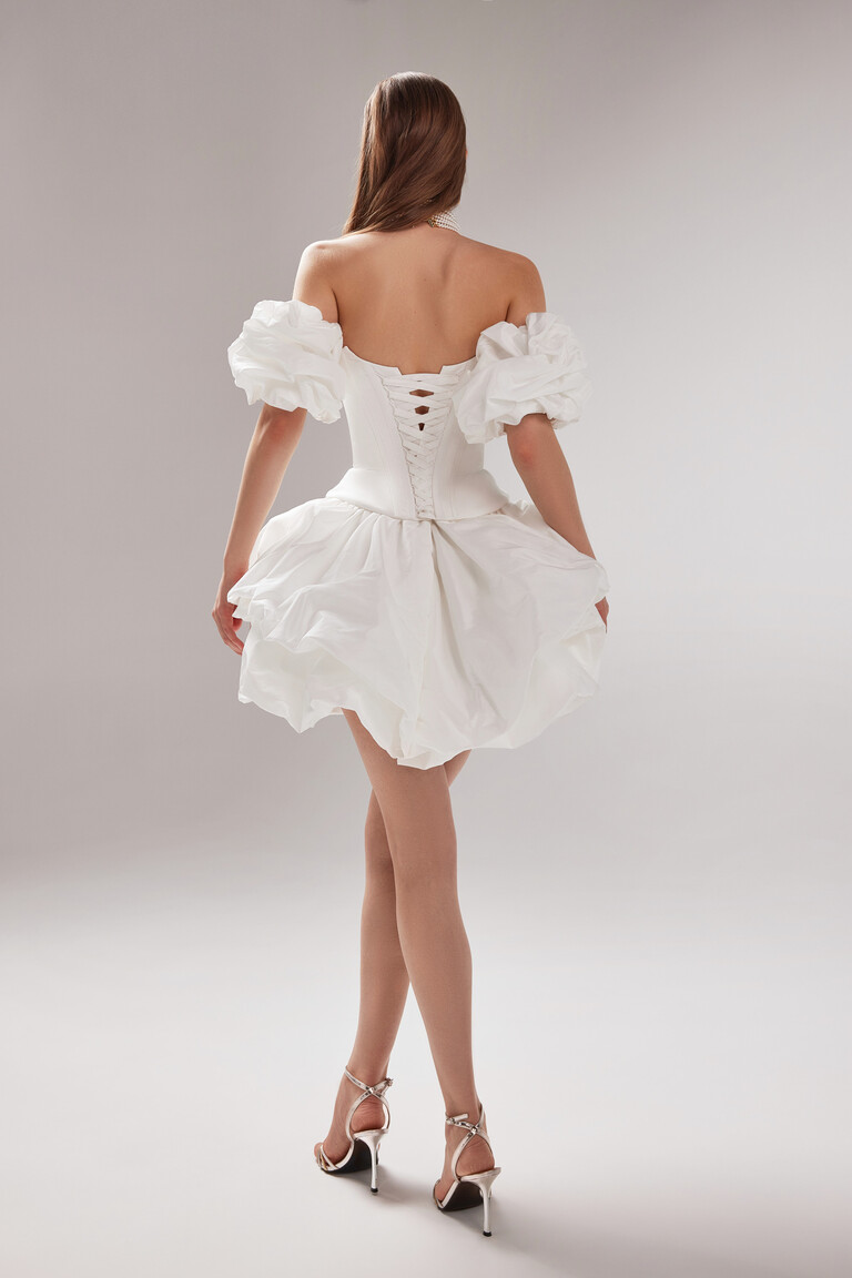Full back view of the convertible Amira Mini ivory taffeta dress with detachable puff sleeves and adjustable corset lacing.