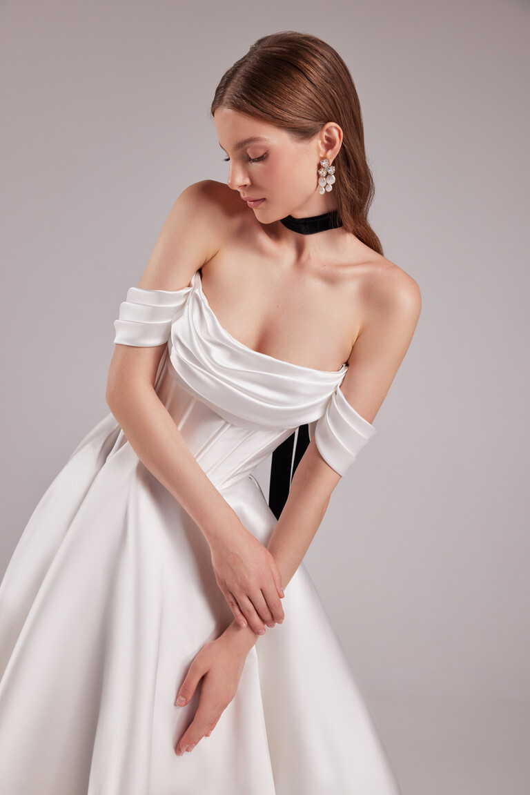 Close-up of Sunny dress corset bodice with draped cowl neck and pearl accessories styling