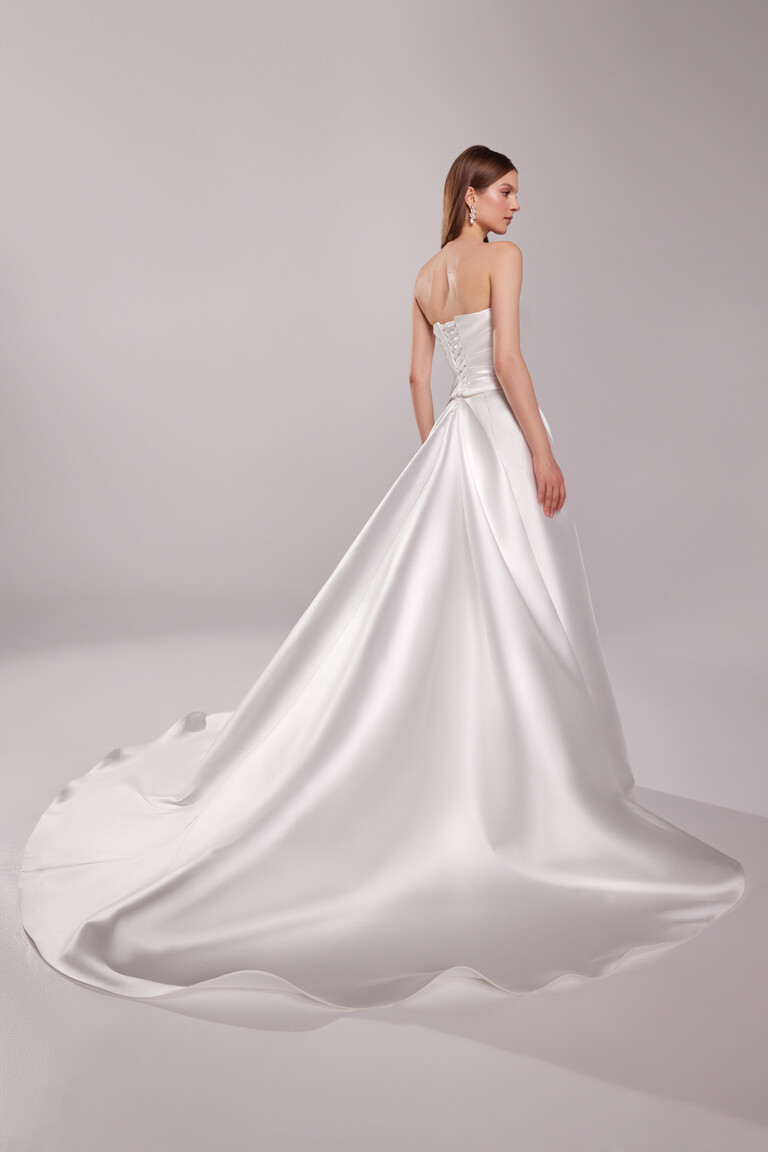 Back view of Unona Tori ivory wedding dress with lace-up corset and sweeping satin train