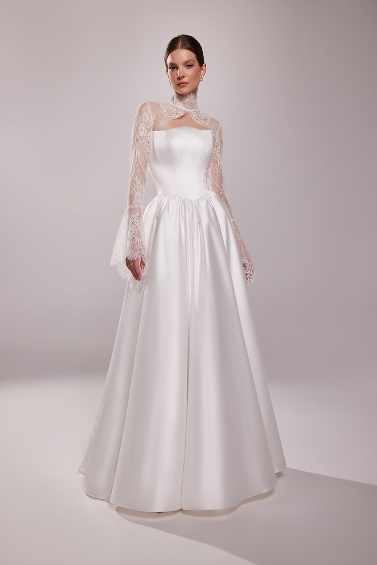 Front view of the ivory Tessa Lace Bolero with a high neckline and bell sleeves styled over a Unona A-line wedding dress.