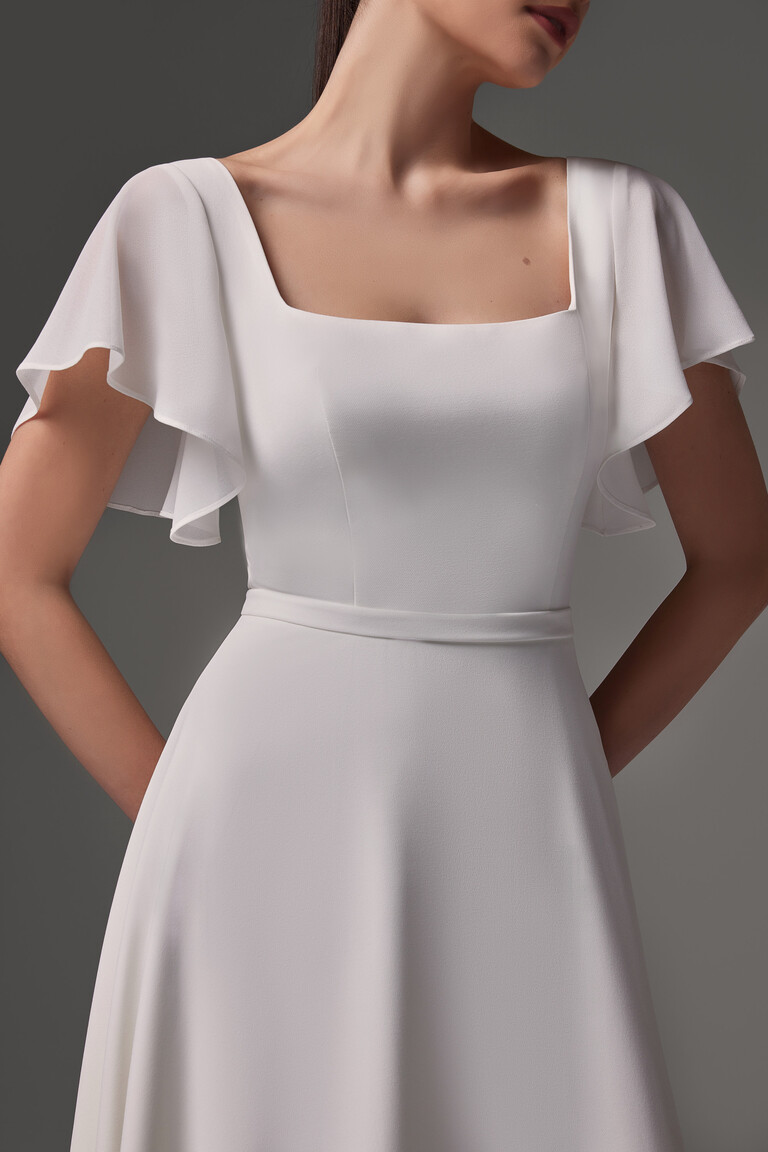 Detail of Edda dress fitted bodice with waist belt and layered flutter sleeves