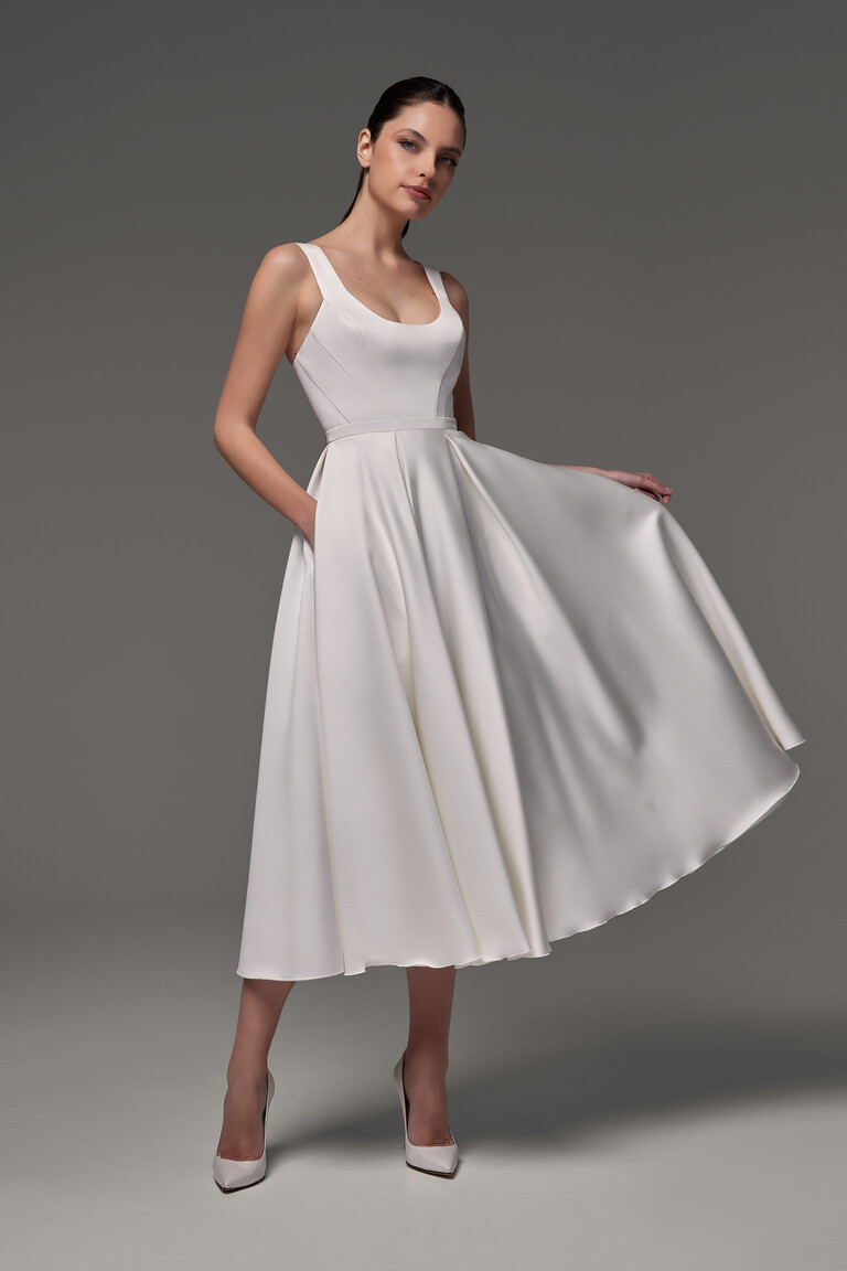 Unona Barbara midi wedding dress in ivory satin, front view showcasing the structured bodice seams and pleated A-line skirt.