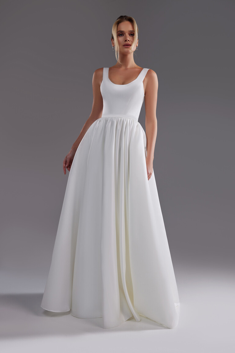 Unona Barbara minimalist A-line wedding dress in ivory satin showing the full silhouette and voluminous skirt from the front.