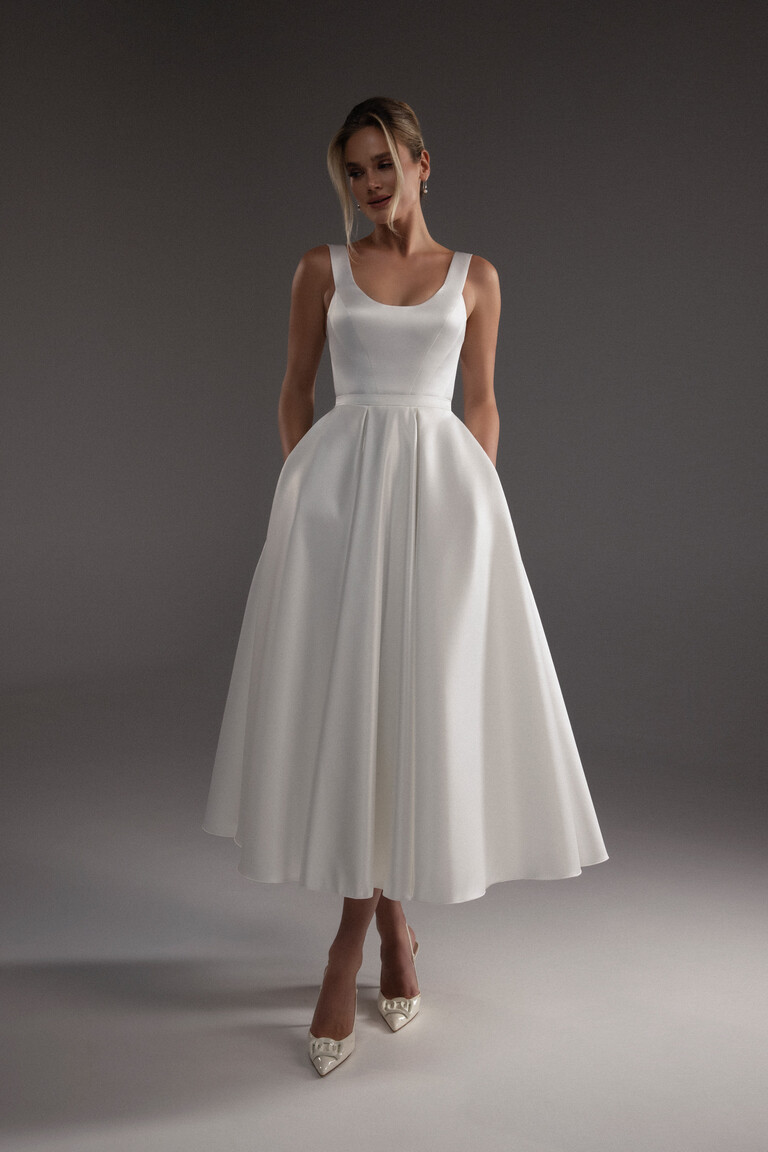 Model wearing the Barbara midi ivory wedding dress full front view, highlighting the structured bodice and voluminous A-line skirt.