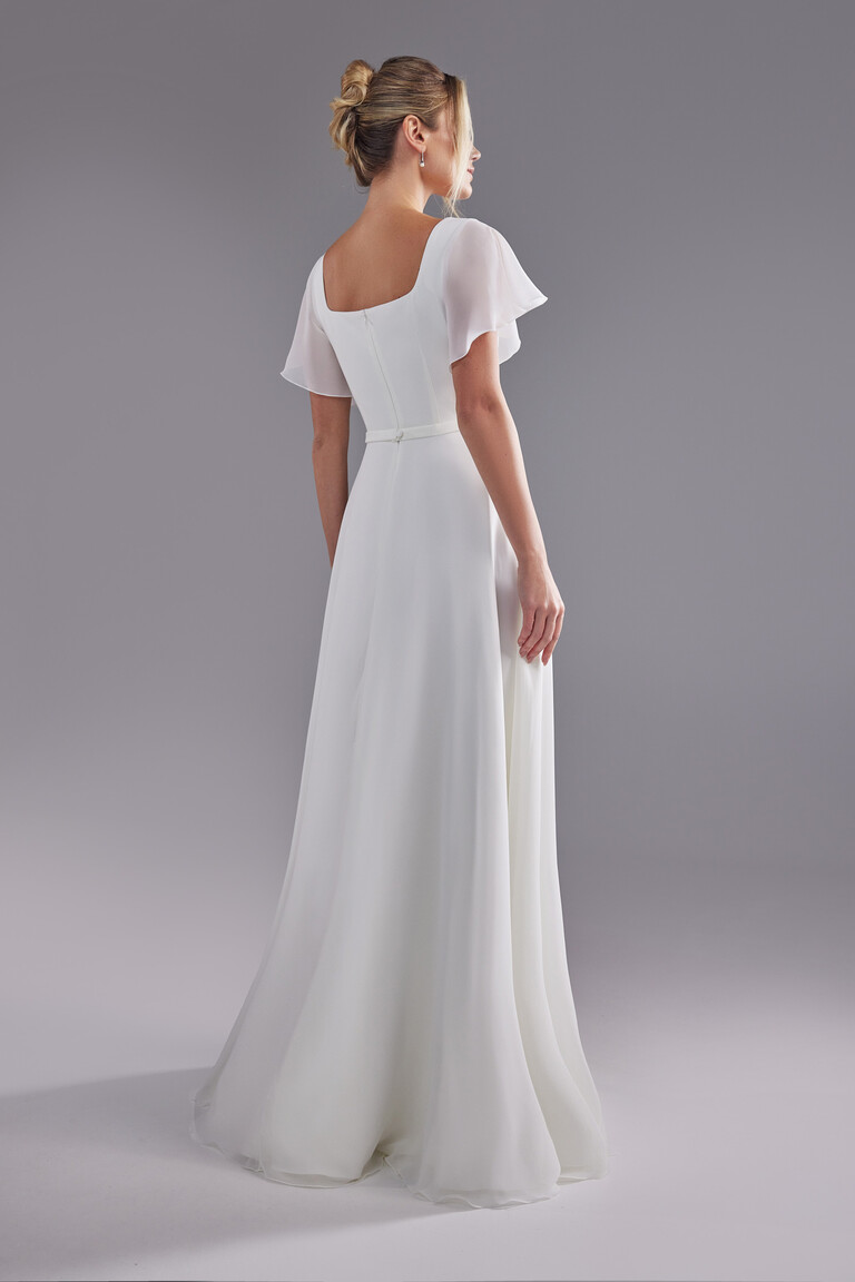 Back view of Edda wedding dress with square back and flowing floor length chiffon skirt