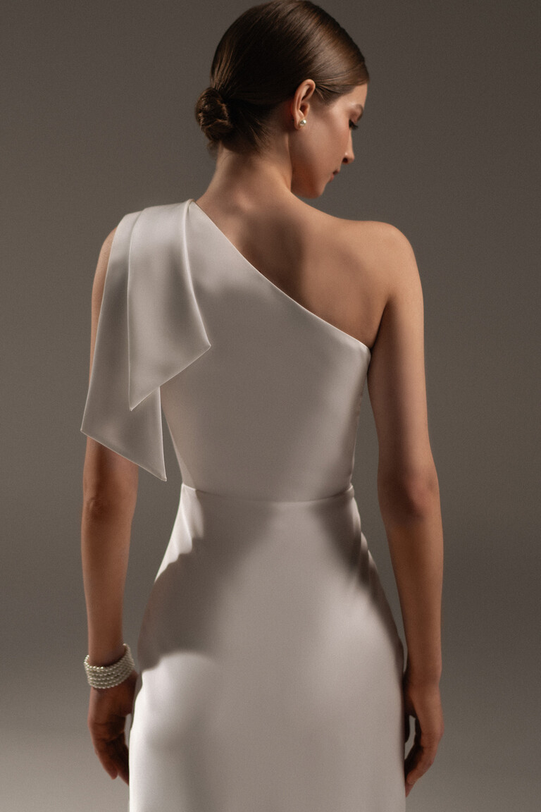 Close-up back view of Julia dress showing structural draped bow on one-shoulder neckline