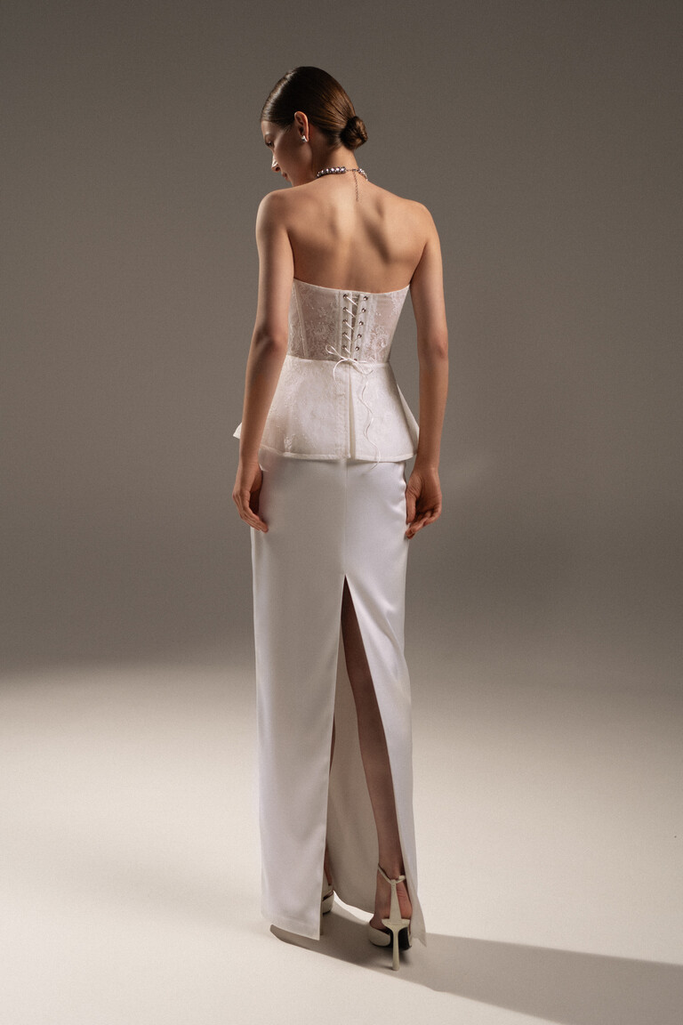 Elegant Lace-Up Back Detail | Alicia Wedding Gown Back view of the Unona Alicia bridal gown highlighting the lace-up corset back, peplum detail, and high slit on the satin column skirt.