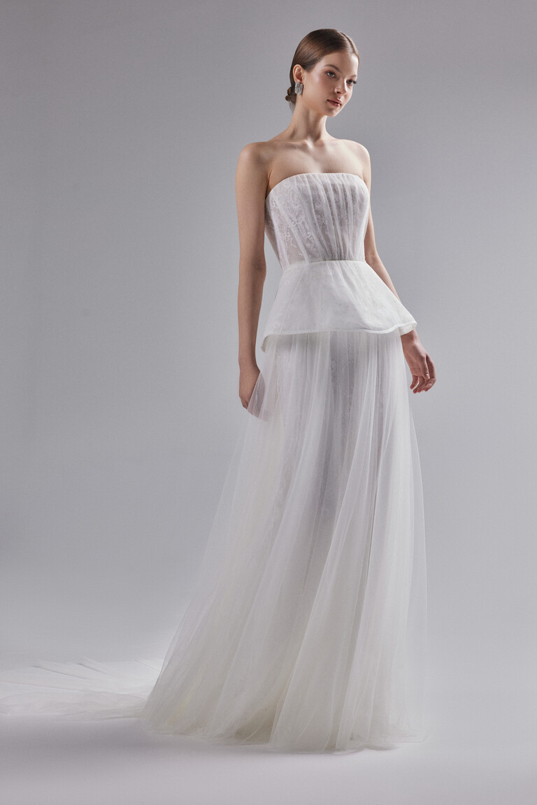 Side angle of Alla wedding dress showing A-line silhouette, peplum, and tulle layers