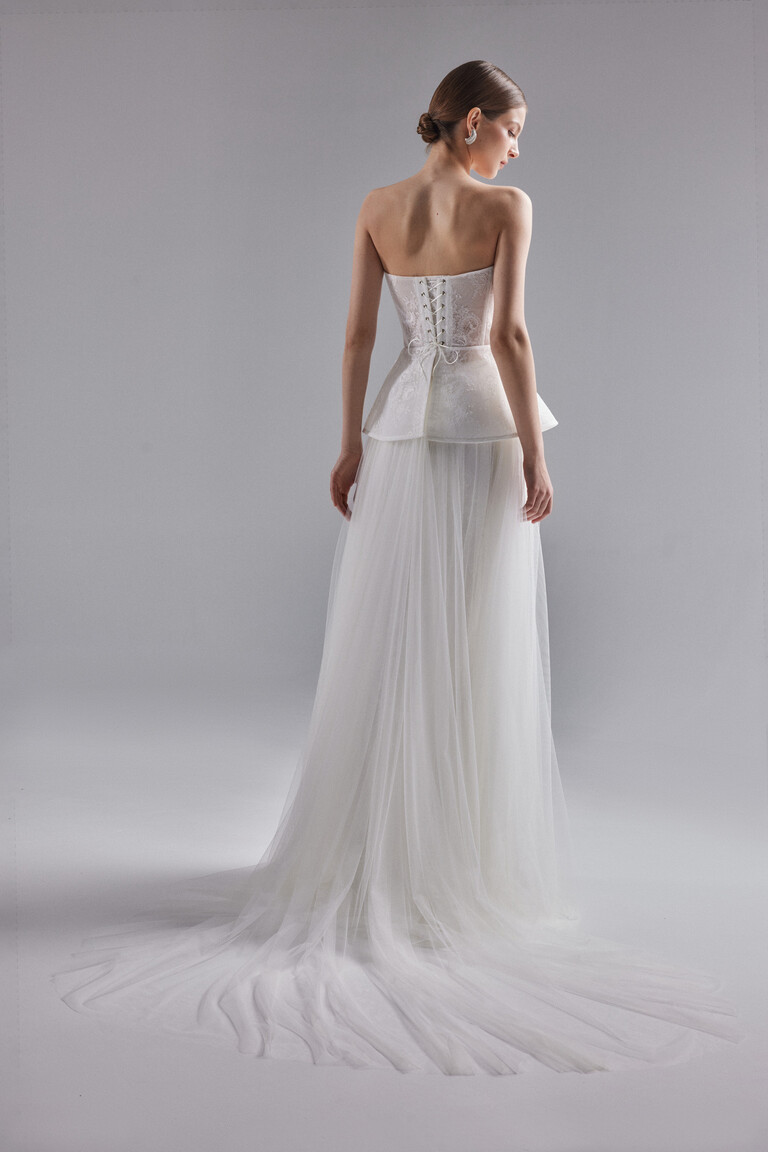 Full length back view of Alla gown with lace-up closure, peplum, and sweeping train