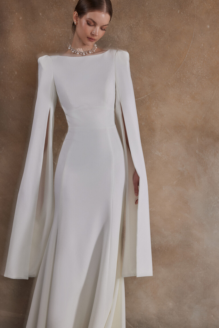 Sleek ivory crepe bridal gown Ashley with padded shoulders and split cape sleeves