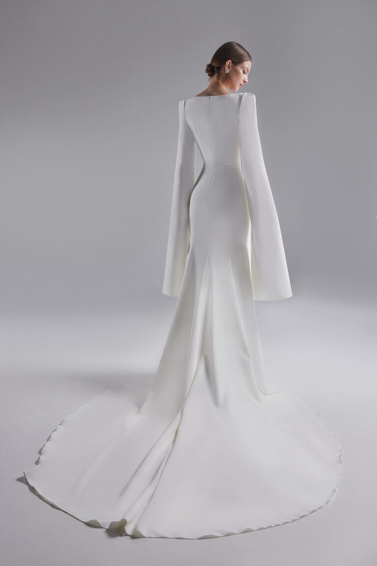 Back view of Ashley ivory wedding dress showing long train and cape sleeve drape