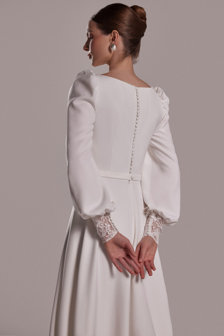 Close up back view of Camalia gown showing fabric covered buttons and floral lace sleeve cuffs