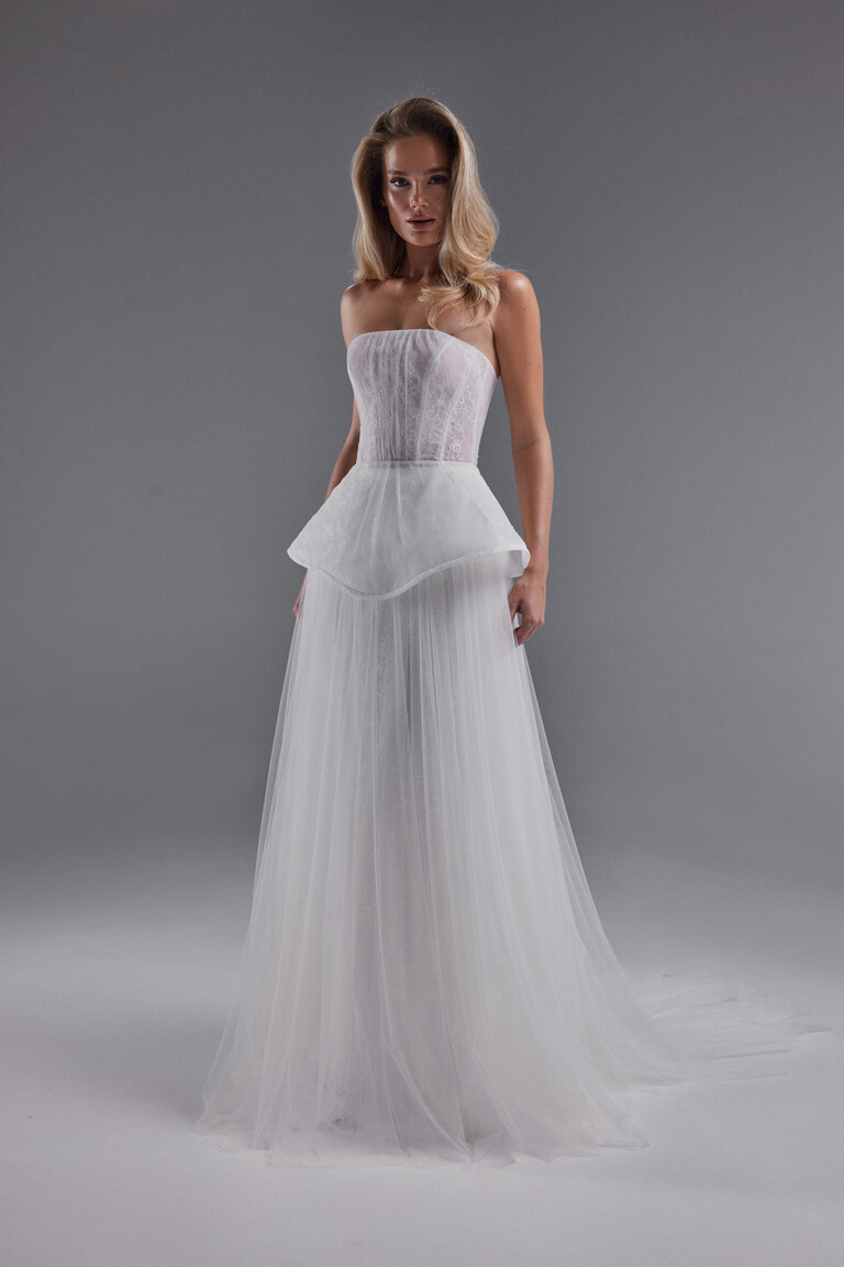 Front view of Alla strapless wedding dress with boned corset, peplum, and tulle skirt