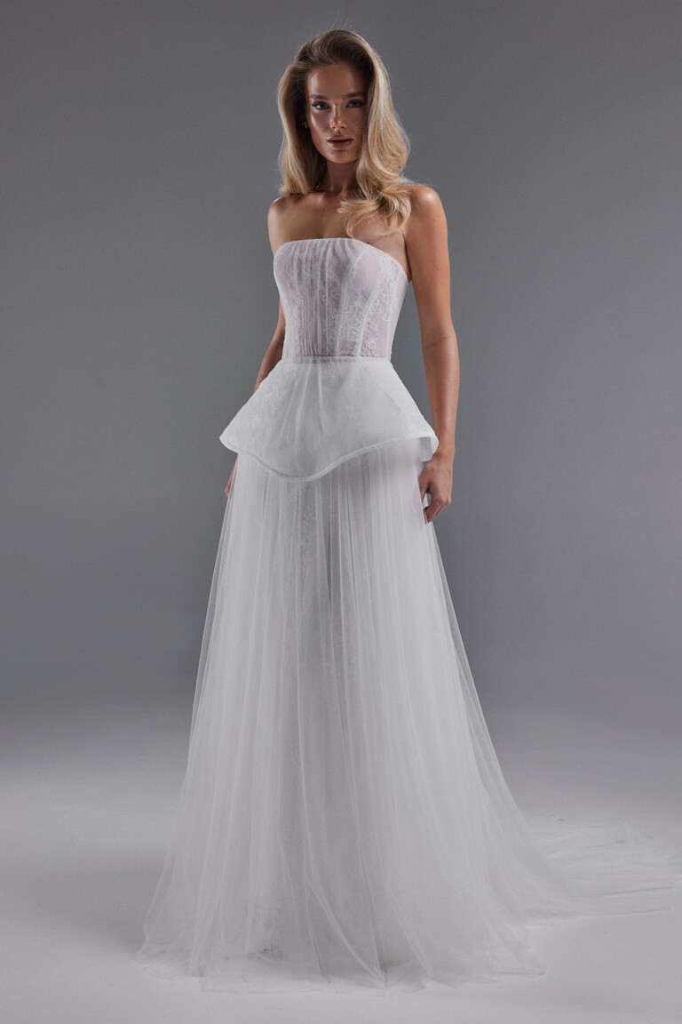 Alla gown front view highlighting pleated tulle skirt, peplum, and lace corset