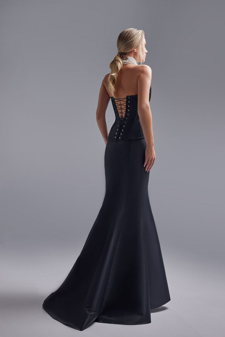 Back view of the Unona Pina black mermaid gown showcasing the lace-up open back detail and the elegant floor-length train.