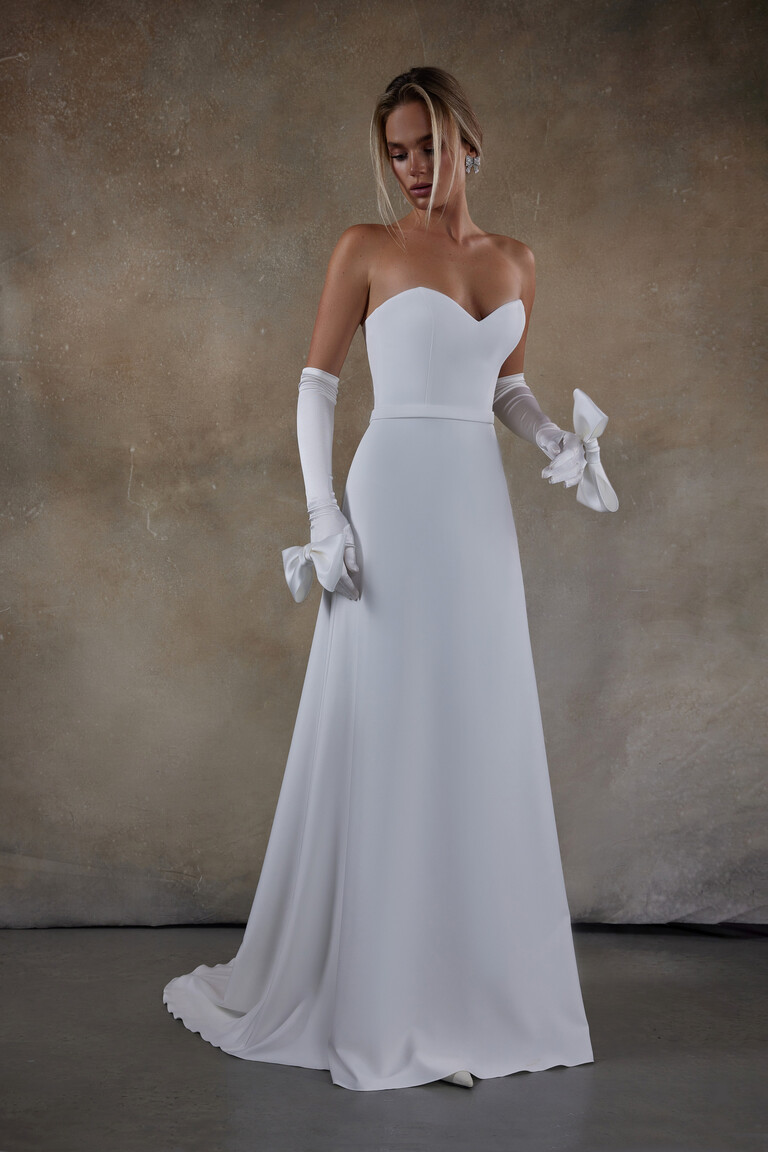 Minimalist Adeline strapless wedding dress in off-white crepe with opera gloves